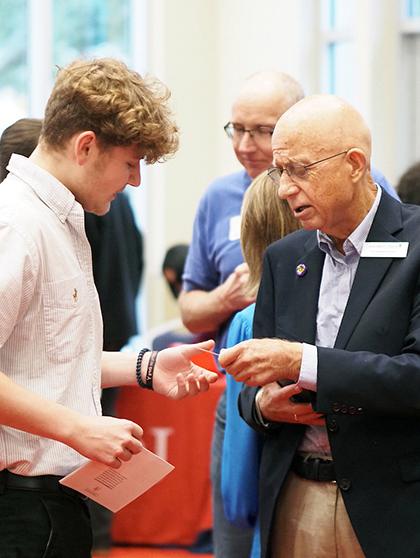 Employer handing a business card to a student.