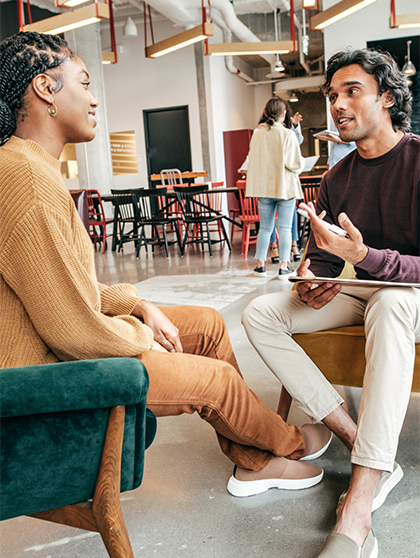 Employer talking to student sitting in chairs.