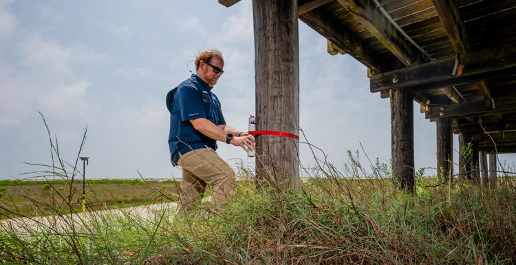 In addition to relying on data from more expensive Sentinels, engineering professor Dr. Bret Webb will deploy smaller storm surge and wave gauges in advance of a hurricane. They can be affixed to structures such as this pier on Dauphin Island.